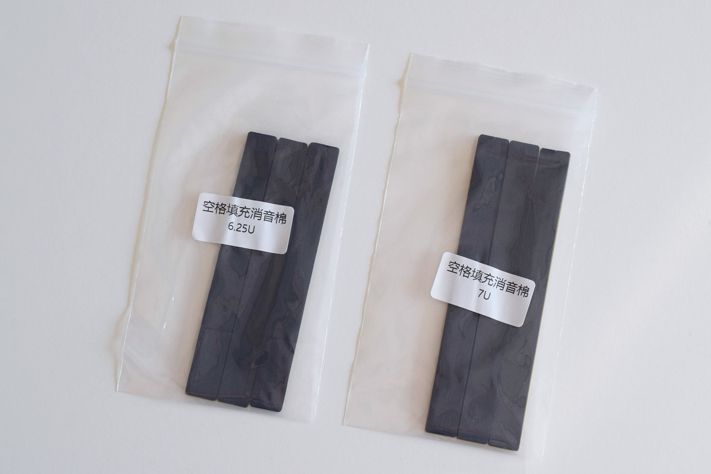 Two packages of black Poron foam strips intended for use as stabilisers under the spacebar of mechanical keyboards.